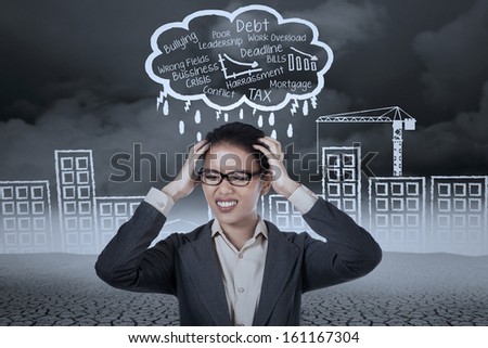 Stressed businesswoman with a headache under stormy clouds