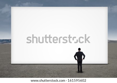 Confident businessman standing in front of empty board outdoor