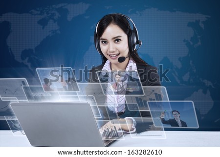 Happy Businesswoman With Pictures Interface In Front Of Laptop On World Map Background