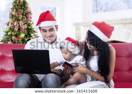 Happy christmas family using laptop computer at home
