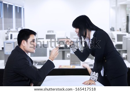 Businesspeople in an Office Fighting and Pointing Fingers at Each Other