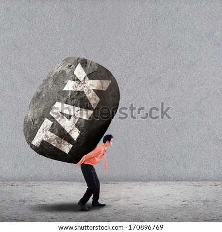 Concept of stress of a businessman carrying a big rock of TAX