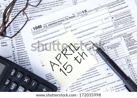 A 1040 tax form and a reminder note with April 15th written on it