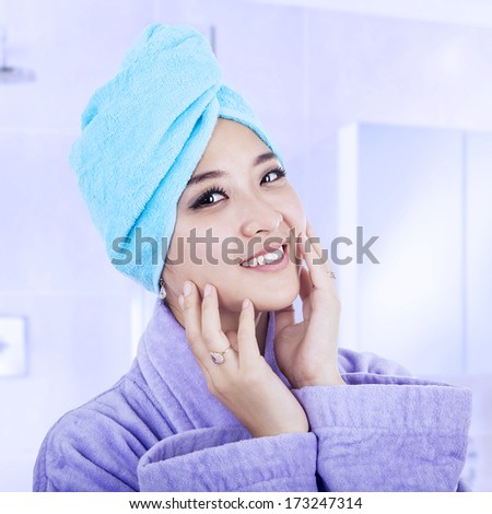 Young woman wrapped in towel after taking bath at home