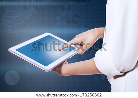 Business woman\'s finger pointing to the screen of a tablet.