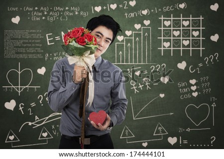 Man with a gift box and flowers standing in front of the formula of love