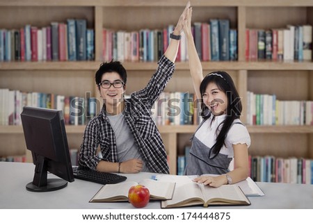 Happy young students in the library