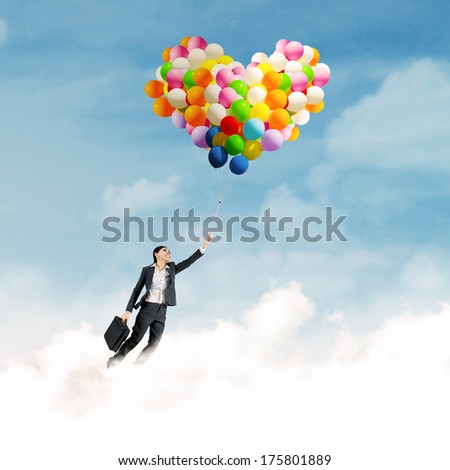 Young businesswoman with colorful balloons and flying over clouds