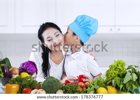 Little chef kissing his mother. shoot in the kitchen