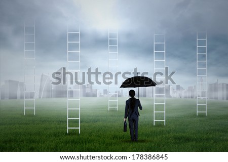 Portrait of business agent holding an umbrella looking at the city