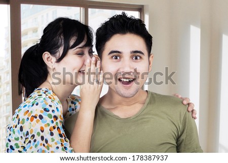 Portrait of a beautiful woman whispering secrets to a man