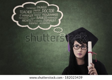 Graduate student in graduation cap is holding certificate thinks about her dream