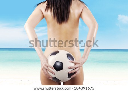 Woman\'s Sexy Backside Holding a Soccer Ball. shooting at beach