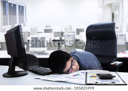 Tired businessman sleeping on the desk. shoot at office