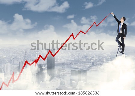 Young businessman on a ladder charting a positive trend graph