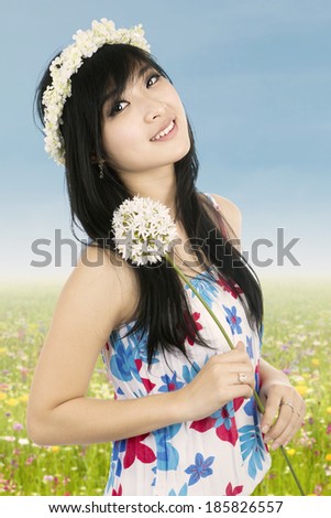 Beautiful woman with crown of flower holding flower
