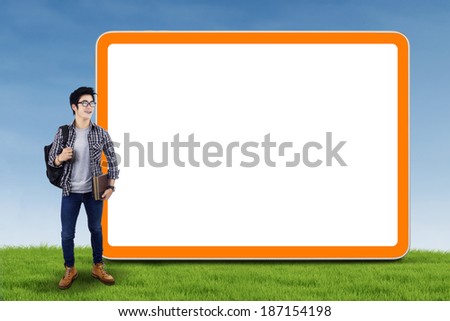 Asian college student standing next to blank copy space for summer sale or other advertising