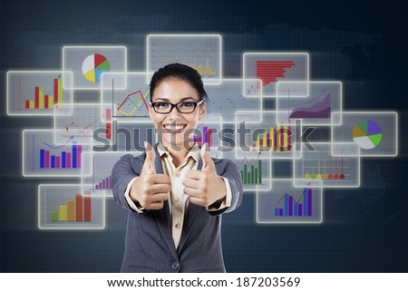 Businesswoman showing thumbs up inf front of uptrend charts