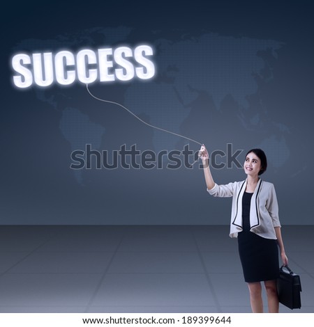 Young businesswoman holding word success on world map background