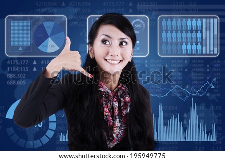 Businesswoman gesturing phone call in front of business chart