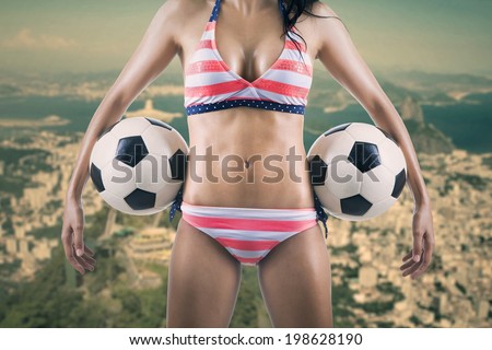 Sexy woman soccer fan holding two balls