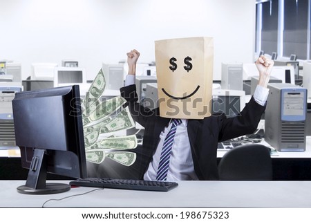 Happy businessman looking money coming out from the computer