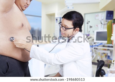 Doctor is checking a fat man. shoot in the hospital