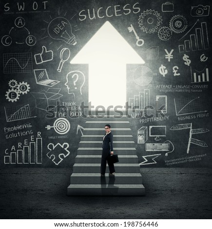 Confident businesswoman standing on the stairs with arrow shaped door