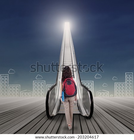 Bright future concept with female college student stepping up on the escalator
