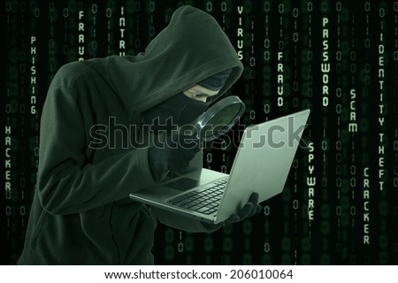 Portrait of hacker looking for user information by using magnifying glass