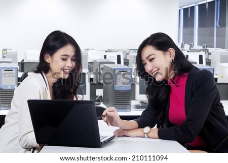 Two beautiful businesswoman office worker discussing in the office