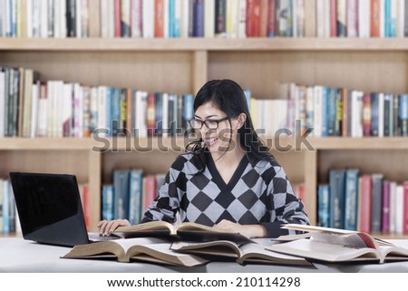 Female student studying at class while typing the source on laptop computer