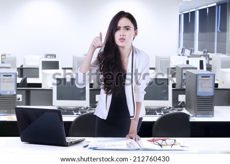 Bossy woman angry and pointing at someone in office