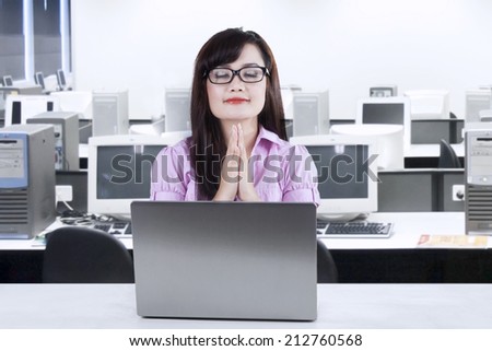 Asian businesswoman praying while working in office