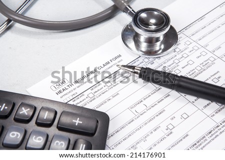 Health insurance concept. Stethoscope, health insurance form, pen, glasses, and calculator.