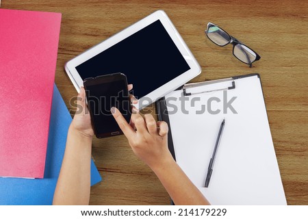 Student studying with digital tablet, smart phone, folder, and clipboard