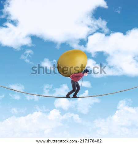 Risky investment: Businessman carrying gold egg of wealth on the rope
