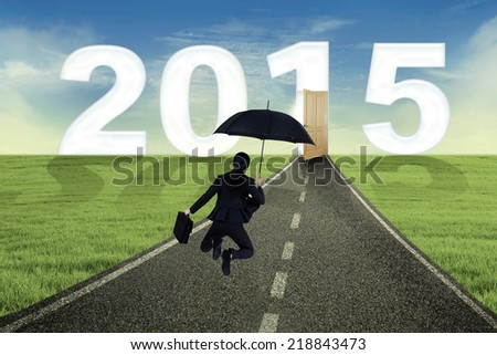 Businesswoman carrying briefcase and happy jump on the road to future 2015