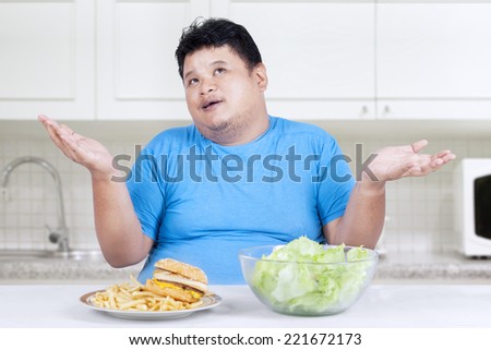 Overweight person doubt to choose junk food or healthy food