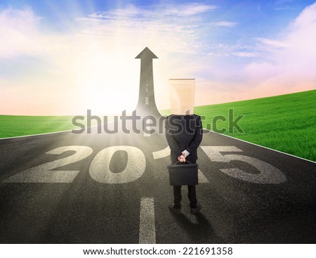 Business person with cardboard head, standing on the road to future 2015