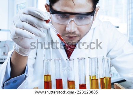 Asian scientist wearing lab coat and instruments research in modern laboratory