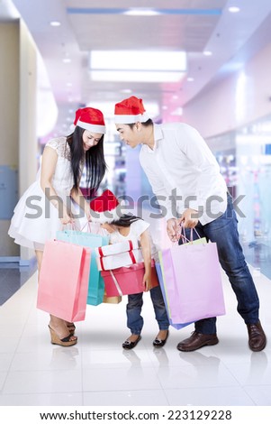 Asian family looking at shopping bags at the mall in christmas day
