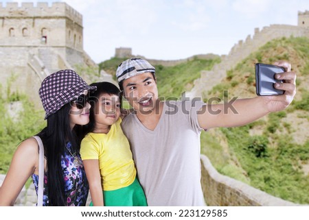 Asian family enjoying holiday and take self portrait together on Great Wall of China