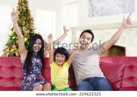 Hispanic family sitting on sofa and expressing happy to celebrate christmas day