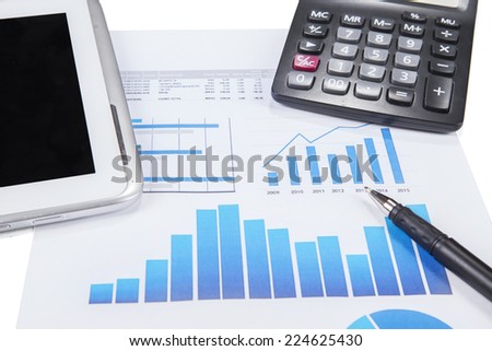 The graph of marketing report with pen, calculator, and a digital tablet on the table