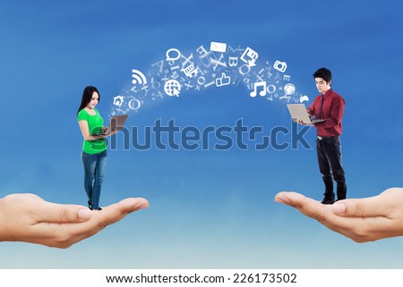 Two people standing on hands while using laptop computer to share information