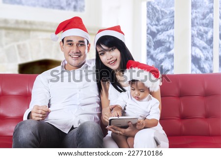 Portrait of beautiful family smiling on camera and enjoy christmas day at home