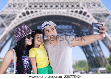 Three member of asian tourist take self portrait together in eiffel tower