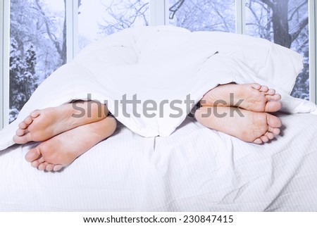 Couple feet sleeping separately on the bedroom, symbolizing couple having family problem