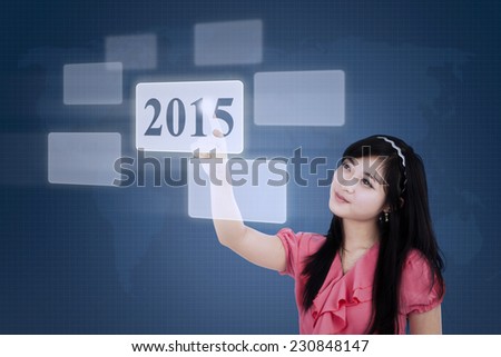 Pretty businesswoman using a virtual screen and select number 2015
